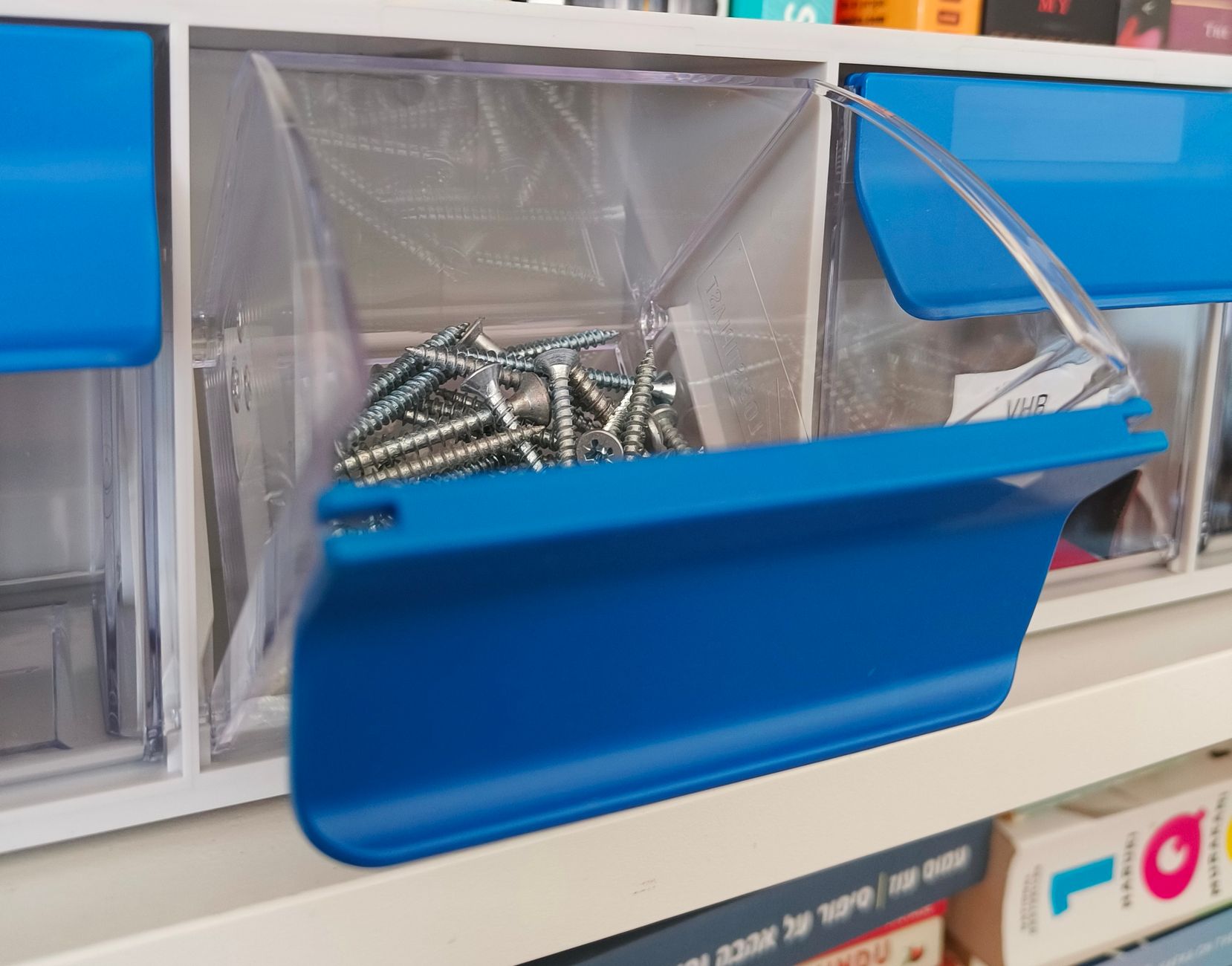 Blue parts bin holding metal fasteners